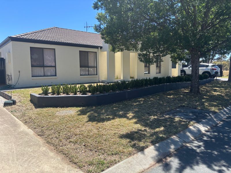 Front yard after: lawn cut short and tidy, garden bed neat